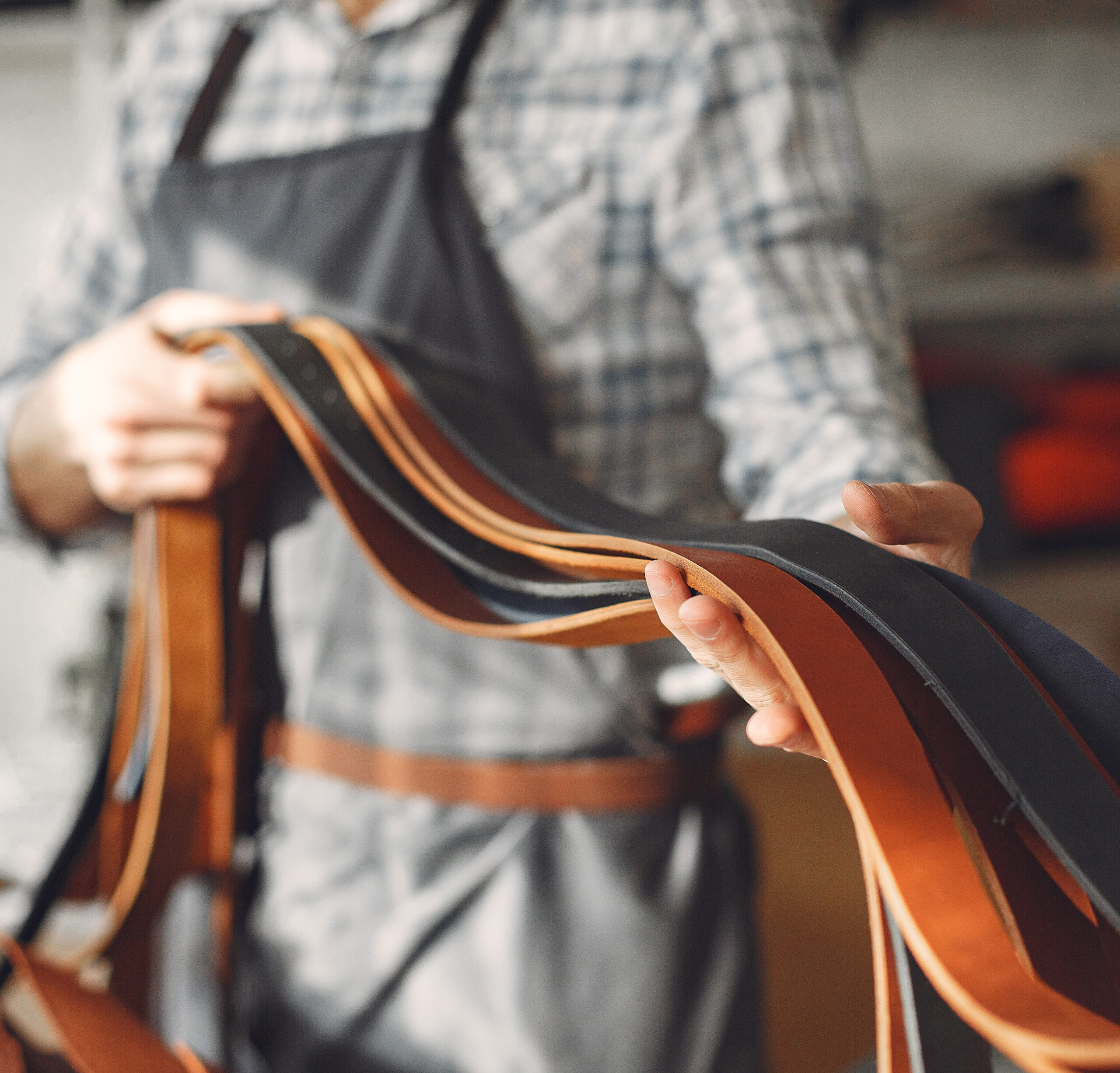 Man working with leather. Professional makes a belts.