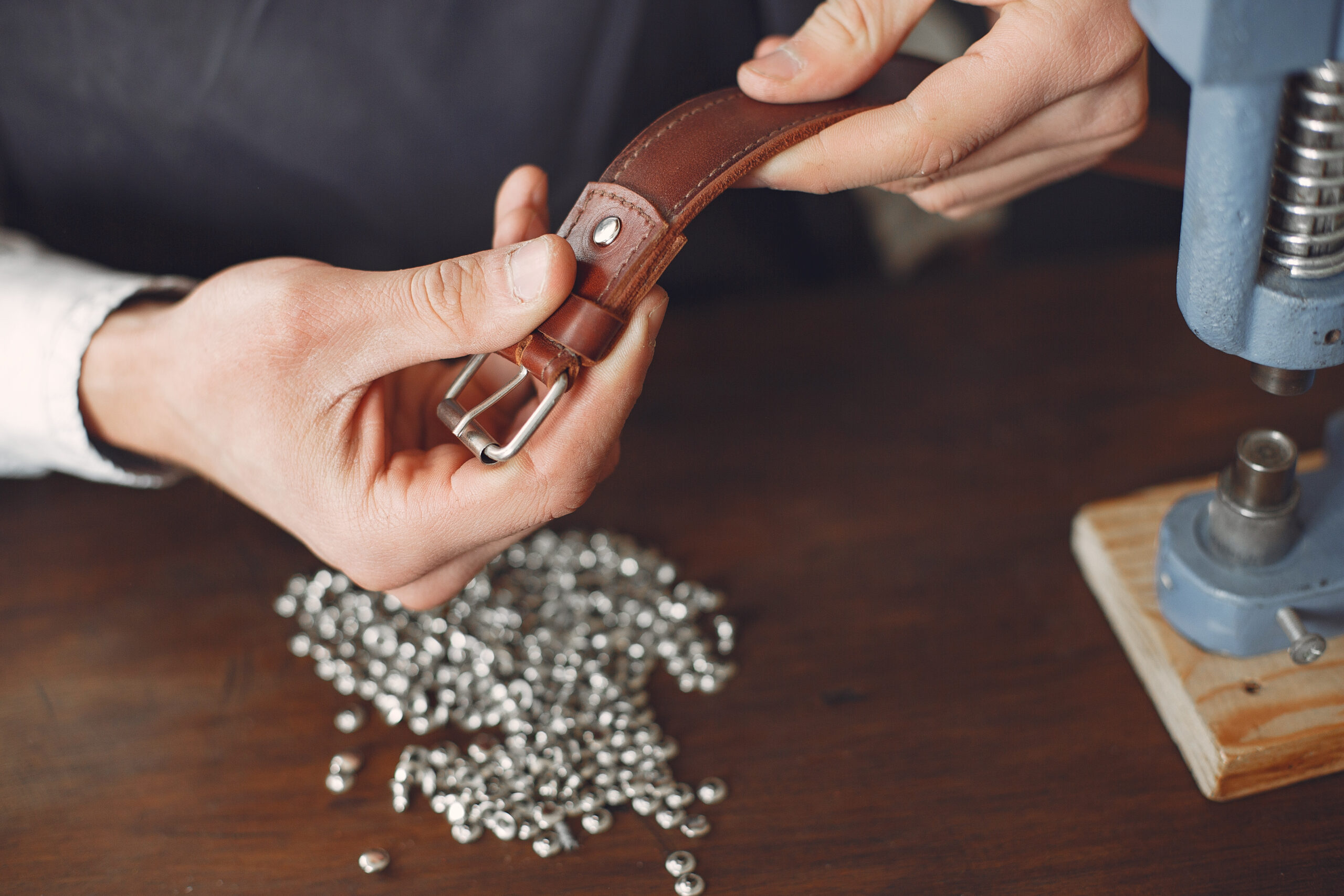 Man working with leather. Professional makes a holes. Man use device for holes.