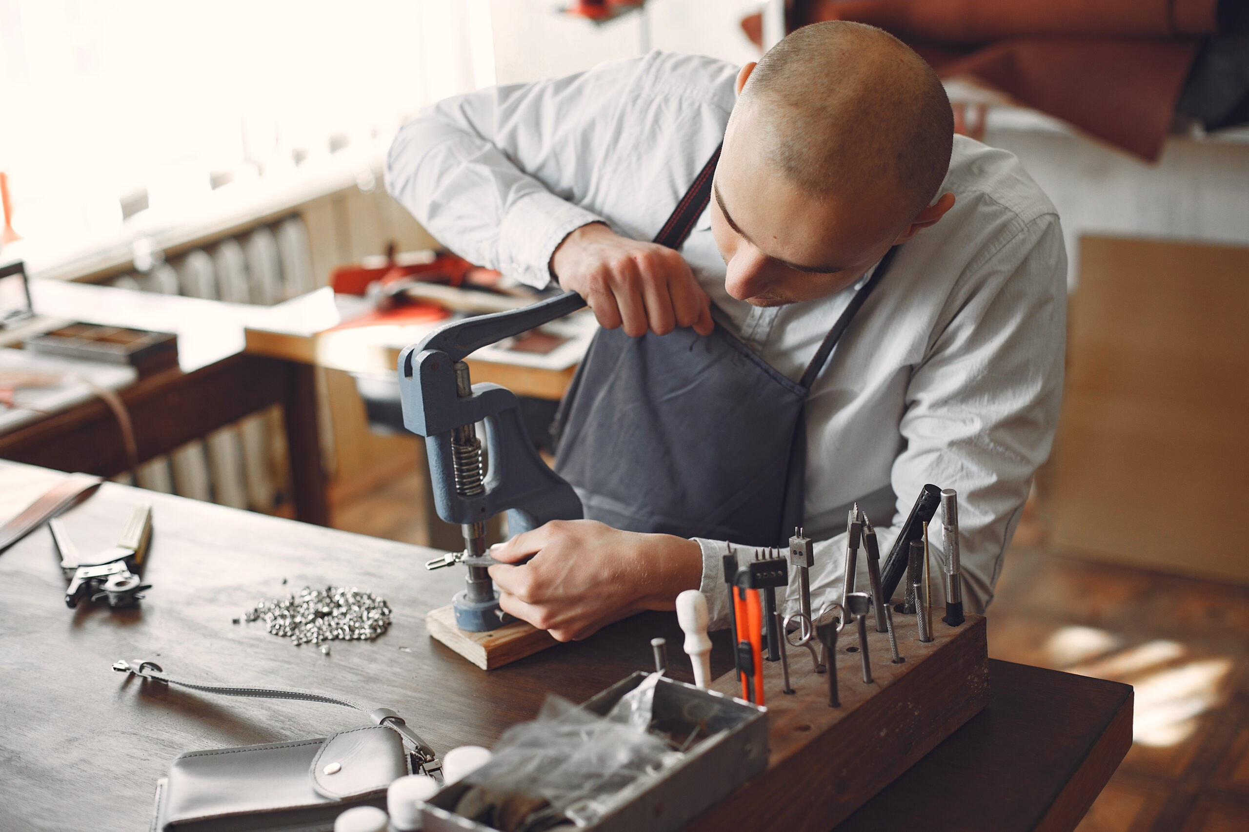 Man working with leather. Professional makes a holes. Man use device for holes.